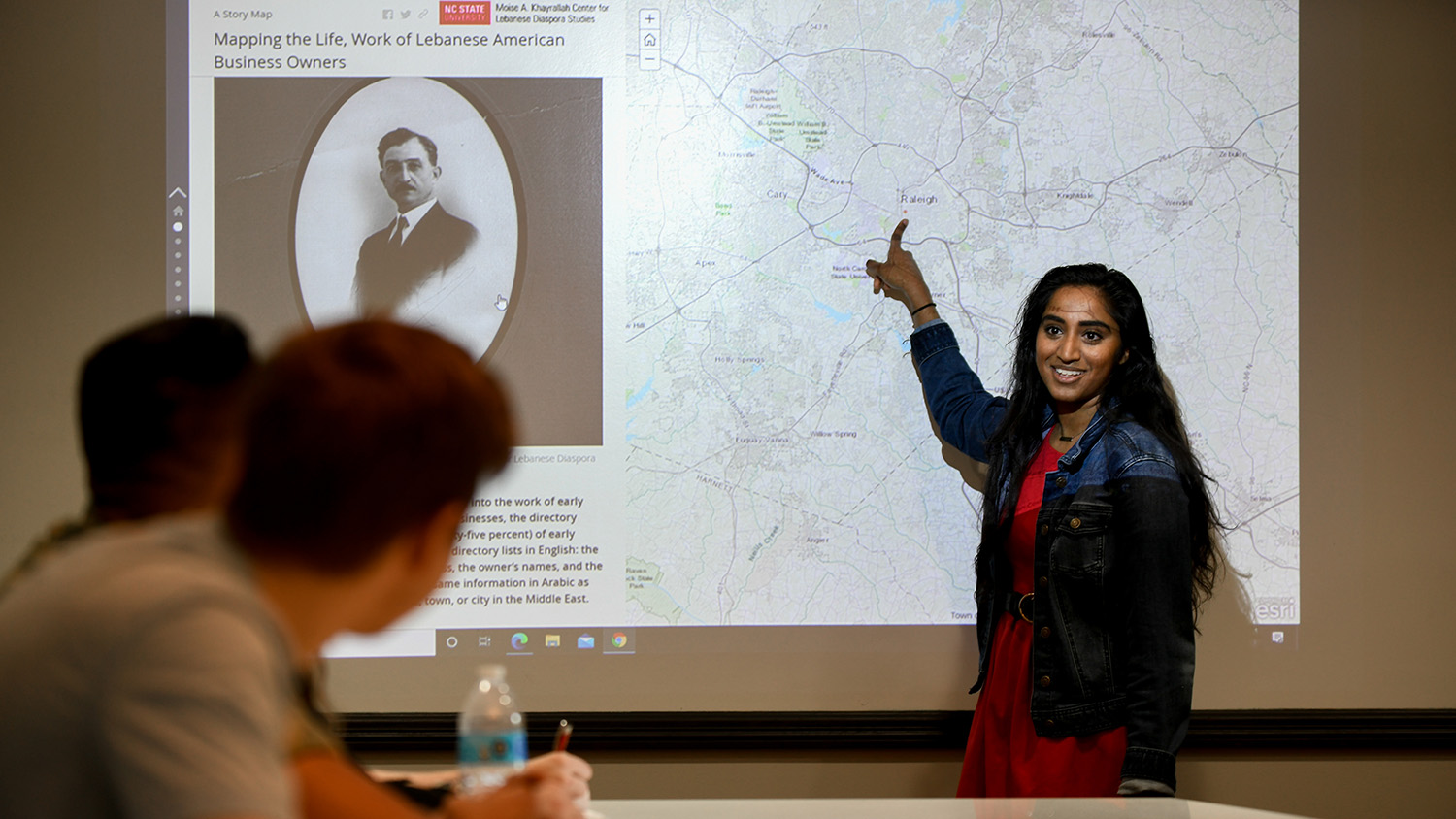 student pointing to presentation on white board