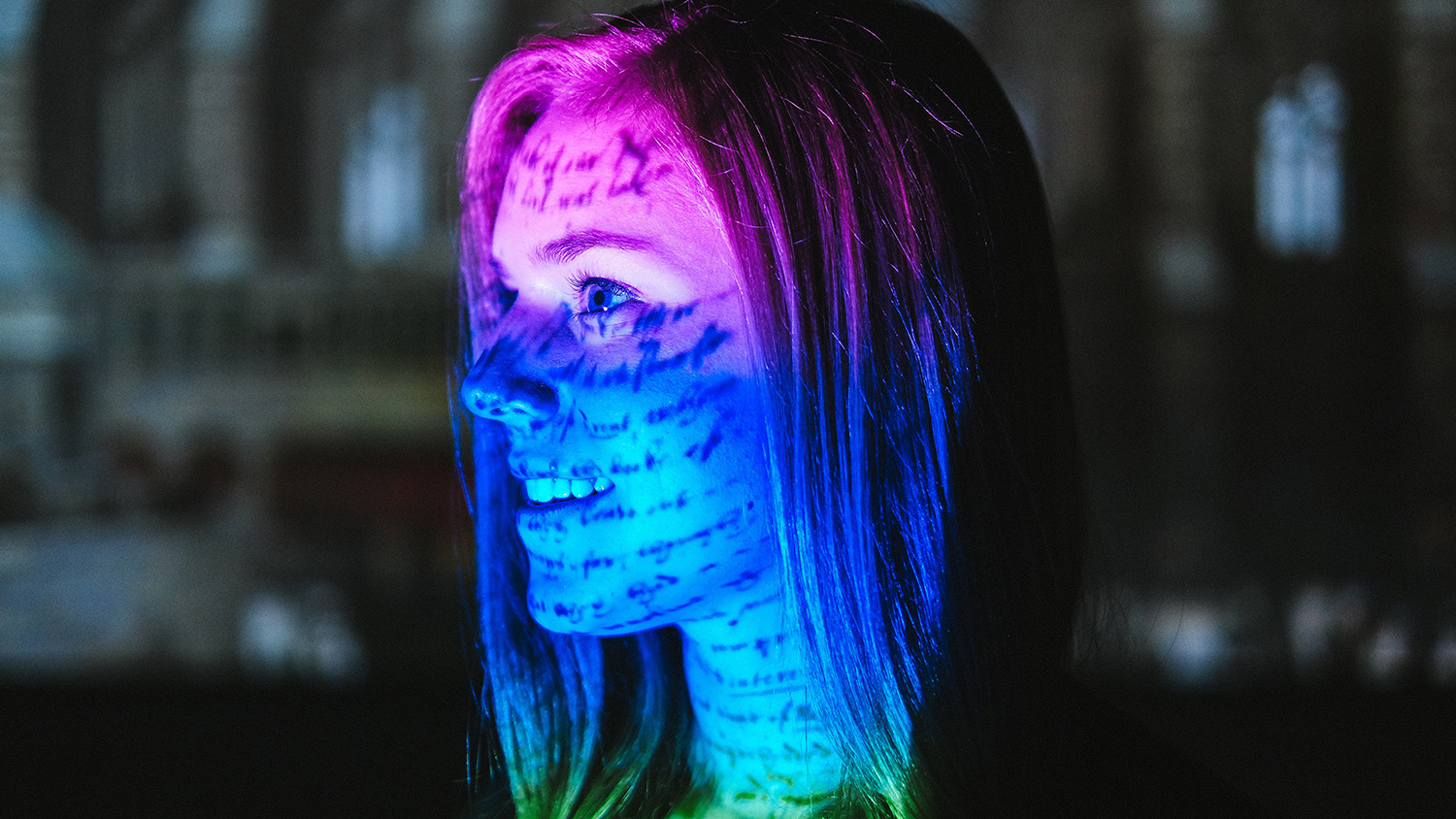 A reflection of a screen shines on a student's face